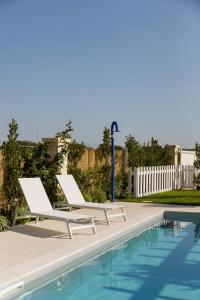 a pair of chairs sitting next to a swimming pool at Masseria Ella in Pulsano