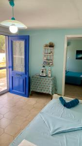 アルテミダにあるRelaxation, Nature and Sea Near the Airport!の青いドア、ベッド、テーブルが備わるベッドルーム1室が備わります。
