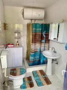 a bathroom with a toilet and a sink at Relaxation, Nature and Sea Near the Airport! in Artemida
