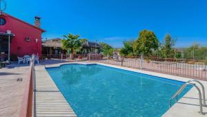 a swimming pool in front of a house with a red building at Casa El Secanillo Loja by Ruralidays in Loja