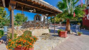 a garden with flowers and a stone wall at Casa El Secanillo Loja by Ruralidays in Loja
