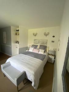 um quarto com uma grande cama branca num quarto em La Grange d'Hélène em Cholet