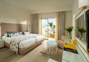 a hotel room with a bed and a balcony at TUI MAGIC LIFE Penelope Beach - Families & Couples in Midoun