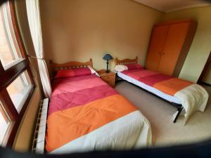 two beds in a room with a window at Con vistas al mar y aparcamiento gratis in Suances