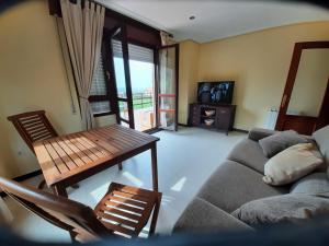 a living room with a couch and a table at Con vistas al mar y aparcamiento gratis in Suances