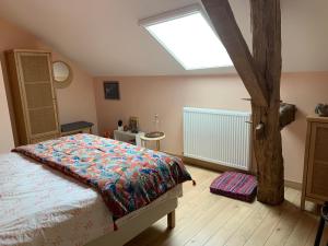 a bedroom with a bed and a skylight at L’En Vert du Monde in Saint-Boil