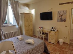 a bedroom with a bed and a desk and a television at Casa Aurora in Ravenna