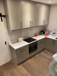 a kitchen with gray cabinets and white counter tops at Dream Cottage in Castletownbere