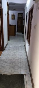 an empty hallway of a house with a tile floor at Hotel Sansar Near Mall Road in Shimla
