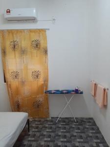 a room with a bed and a curtain and a table at Homestay Idaman B B with 2 room aircond 2 Quen Bed and Not Sharing Room -Privacy in Kuala Terengganu