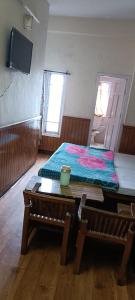 a room with a bed and a table and a table sidx sidx at Hotel Sansar Near Mall Road in Shimla