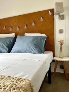a bedroom with a bed with blue pillows and a headboard at CAMPING GALLINA VARJA in Sotta