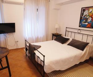 a bedroom with a bed and a table and a television at Jerry & Oli's Apartments in Šibenik