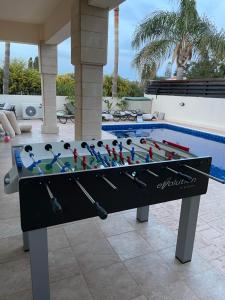una mesa de ping pong frente a una piscina en Luxury spacious holiday Villa with heated swimming pool, en Paralimni