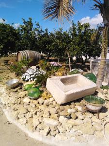 um jardim de pedra com um lavatório de pedra no meio em SALINA APPARTAMENTI em Trapani