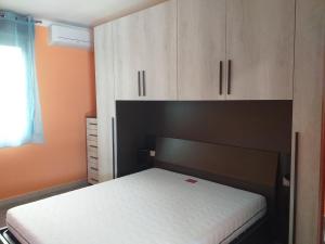 1 dormitorio con 1 cama y armarios de madera en ORANGE HOUSE, en Bosa