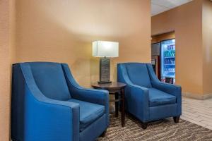 duas cadeiras azuis sentadas ao lado de uma mesa com um candeeiro em Comfort Inn & Suites Orlando North em Sanford