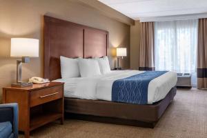 a hotel room with a large bed and a telephone at Comfort Inn & Suites Orlando North in Sanford