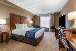 a hotel room with a bed and a flat screen tv at Comfort Inn & Suites Orlando North in Sanford