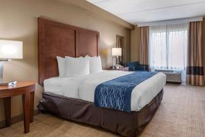 a hotel room with a large bed and a desk at Comfort Inn & Suites Orlando North in Sanford