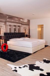 ein Schlafzimmer mit einem großen weißen Bett und einem Gemälde in der Unterkunft Hotel im Haus zur Hanse in Braunschweig