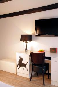 a room with a desk and a table with a lamp at Hotel im Haus zur Hanse in Braunschweig