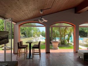 sala de estar con mesa, sillas y piscina en Villa Mischa, en Bevazzana
