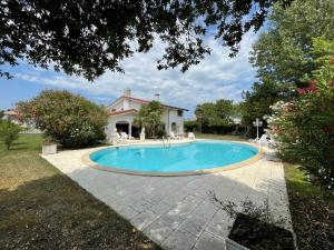 a swimming pool in front of a house at Villa Lorivita in Bevazzana