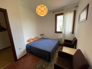 a bedroom with a bed and a chair at Villa Lorivita in Bevazzana