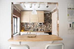 a kitchen with a wooden table and white chairs at Casa da Avó Bé in Portalegre
