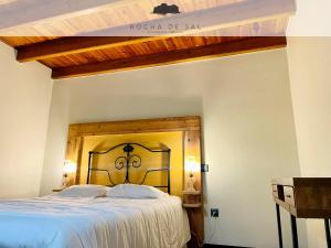 a bedroom with a large bed with a wooden headboard at Casa Flor de Sal in São Mateus