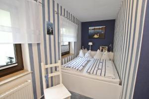 マルヒョーにあるFerienhaus Malchow SEE 7751の青い壁のベッド付きの小さなベッドルーム1室