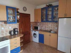 una cucina con armadi blu e frigorifero bianco di DoMo apartment a Středokluky