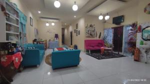 a living room with blue and red chairs in a room at D-Rima Homestay Ruteng in Ruteng