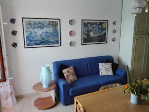 un divano blu in soggiorno con immagini appese al muro di Un tuffo in mare a Genova Altre 27 foto