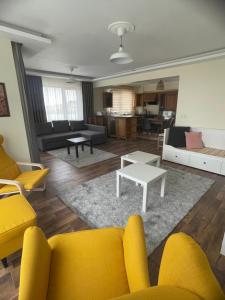 a living room with yellow chairs and a couch at Sultan Villa, Merkez Mahallesi Dogu Sirti Caddesi Sultan Sitesi H-2 in Kadıköy