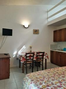 Una habitación con una mesa y sillas y una cocina. en Agriturismo Il Cipresso, en Vada