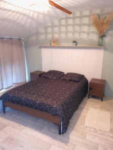 een slaapkamer met een bed met een paars dekbed bij Le Clos du Lys in Châlons-en-Champagne