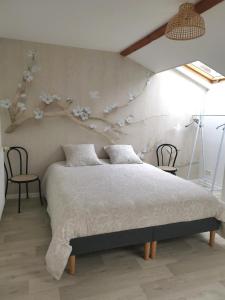 een slaapkamer met een bed met bloemen aan de muur bij Le Clos du Lys in Châlons-en-Champagne