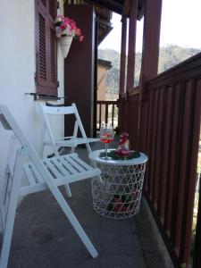 una silla blanca y una copa de vino en el balcón en Fiordiluna near 5 terre en Beverino
