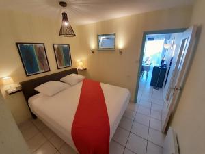 阿格德角的住宿－Appartement Village Naturiste Paradoxe，一间卧室,床上铺有红色条纹的床