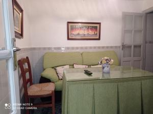 un soggiorno con divano e tavolo in vetro di Casa típica de pueblo andaluz a Villanueva de San Juan
