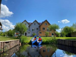 two boats in a canal in front of a house at KapLuv Plau am See in Plau am See