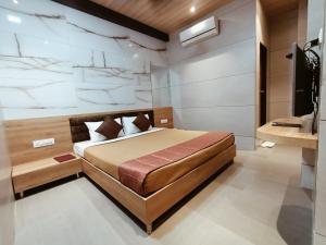a bedroom with a bed and a television in it at Hotel Prasad NX in Mumbai