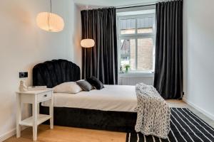a bedroom with a bed with a chair and a window at Jan III Sobieski - Luksusowy apartament L z darmowym prywatnym parkingiem in Gliwice