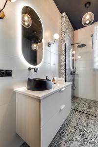 a bathroom with a black sink and a mirror at Jan III Sobieski - Luksusowy apartament L z darmowym prywatnym parkingiem in Gliwice