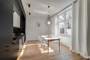 a kitchen with a table and chairs and a window at Jan III Sobieski - Luksusowy apartament L z darmowym prywatnym parkingiem in Gliwice