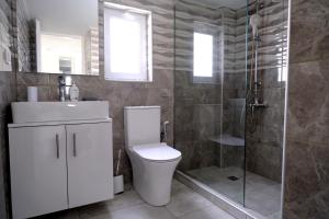 a bathroom with a toilet and a glass shower at Erinaki Apartments in Kissamos