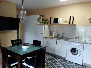 - une cuisine avec une table et un lave-linge dans l'établissement One bedroom house with enclosed garden and wifi at Parada, à Parada