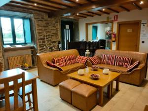 Sala de estar con 2 sofás y mesa en Pension Albergue Alborada, en Salceda